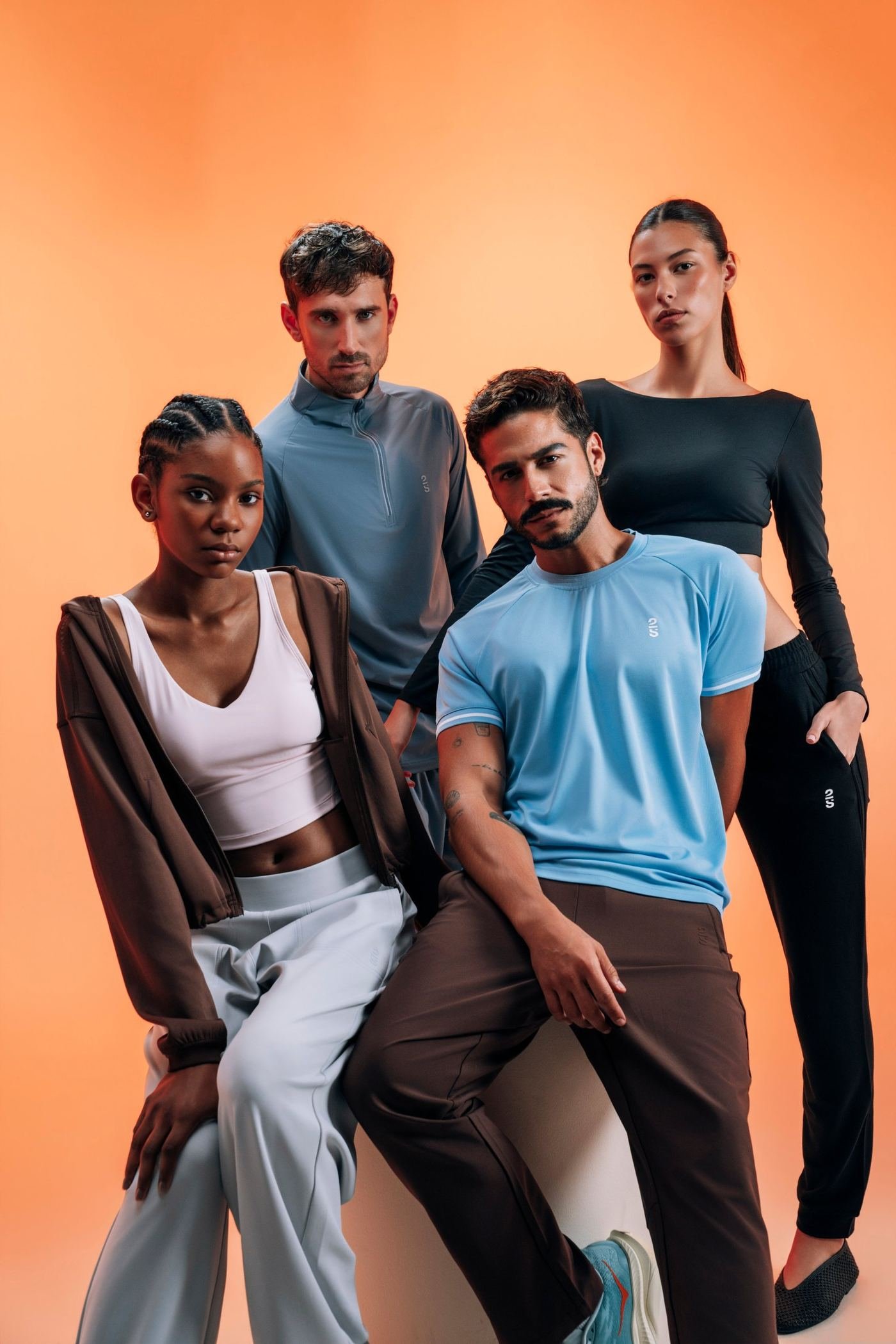 Cuatro modelos con prendas 2S de la colección Spring Summer 2026 sobre fondo naranja